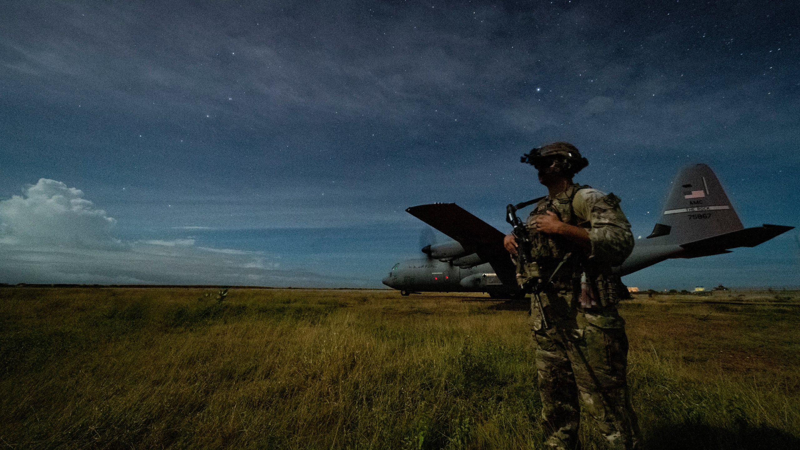 U.S. Army Spc. Kevin Martin, junior sniper, assigned to the 1-186th Infantry Battalion, Task Force Guardian, Combined Joint Task Force - Horn of Africa, provides security for a 75th Expeditionary Airlift Squadron (EAS) C-130J Super Hercules during unloading operations at an unidentified location in Somalia Sunday, June 28, 2020. (Tech. Sgt. Christopher Ruano/Combined Joint Task Force - Horn of Africa via AP)