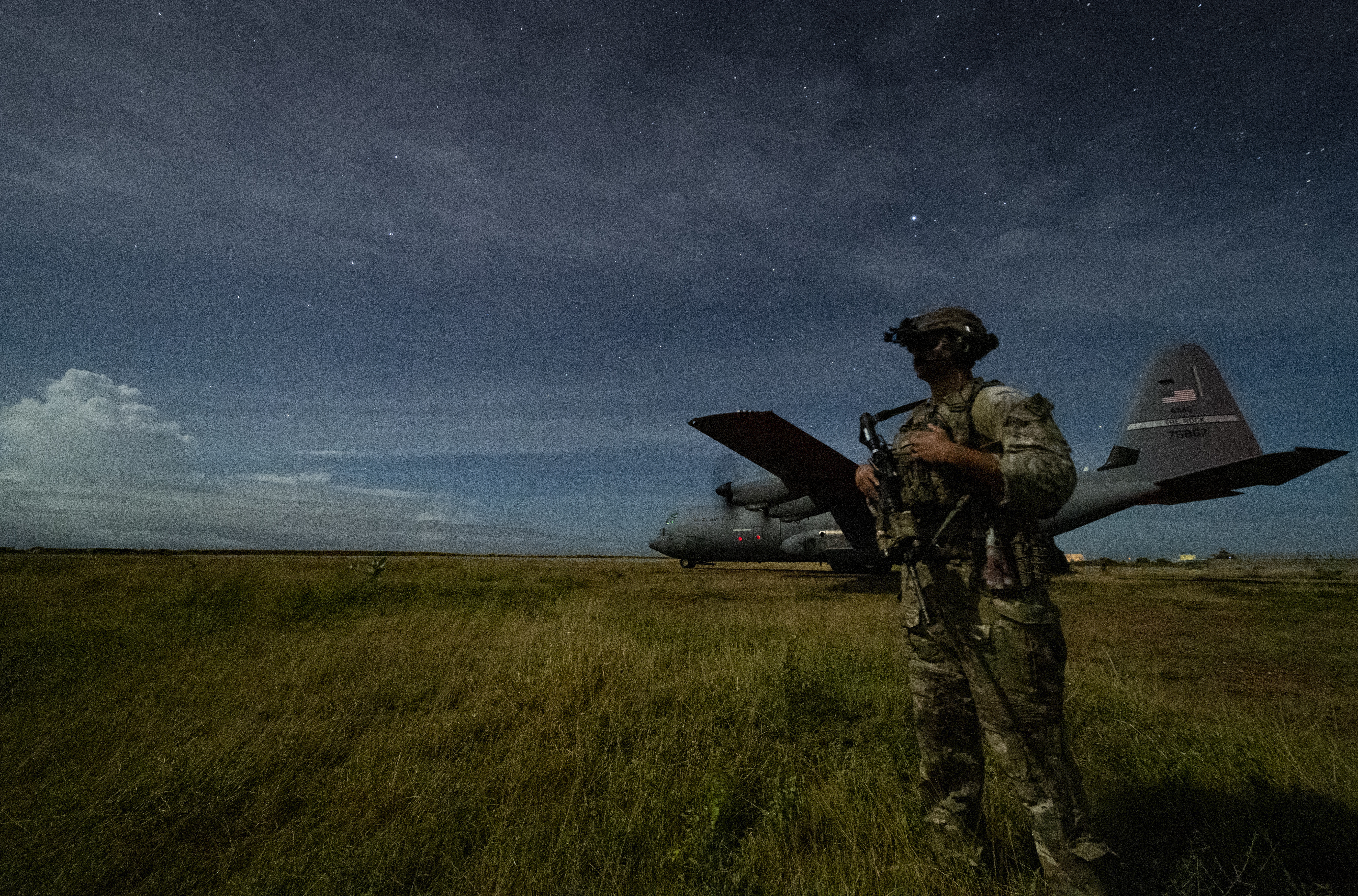 U.S. Army Spc. Kevin Martin, junior sniper, assigned to the 1-186th Infantry Battalion, Task Force Guardian, Combined Joint Task Force - Horn of Africa, provides security for a 75th Expeditionary Airlift Squadron (EAS) C-130J Super Hercules during unloading operations at an unidentified location in Somalia Sunday, June 28, 2020. (Tech. Sgt. Christopher Ruano/Combined Joint Task Force - Horn of Africa via AP)