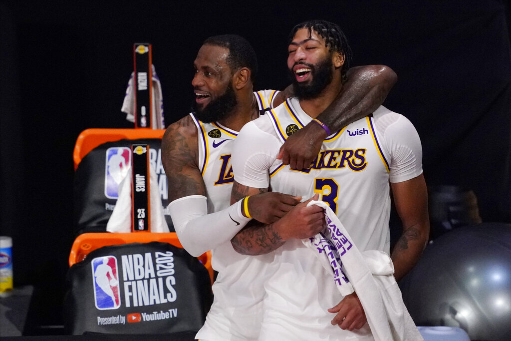 Los Angeles Lakers' LeBron James, rear, and Anthony Davis (3) celebrate after the Lakers defeated the Miami Heat 106-93 in Game 6 of basketball's NBA Finals in Lake Buena Vista, Fla., in this Oct. 11, 2020, file photo. (AP Photo/Mark J. Terrill, File)