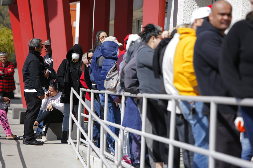 In this March 17, 2020, file photo, people wait in line for help with unemployment benefits at the One-Stop Career Center in Las Vegas. (AP Photo/John Locher, File)