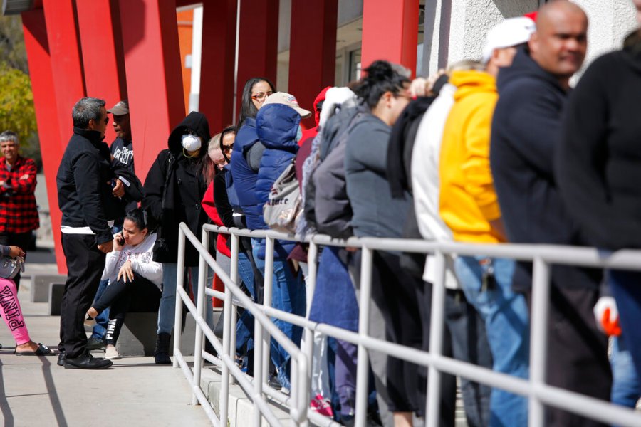 In this March 17, 2020, file photo, people wait in line for help with unemployment benefits at the One-Stop Career Center in Las Vegas. (AP Photo/John Locher, File)