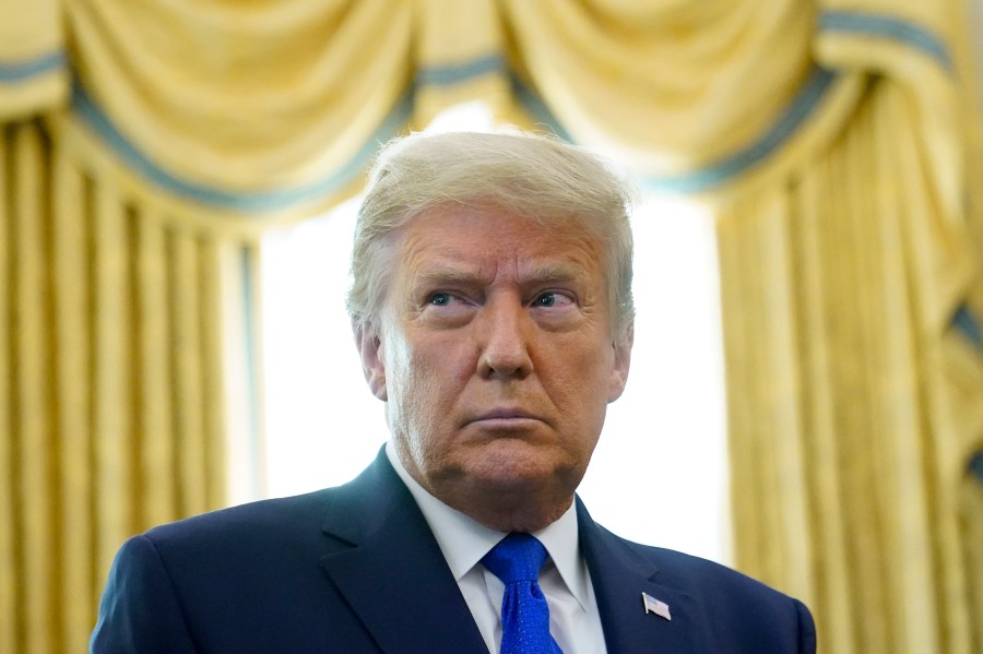 President Donald Trump prepares to award the Presidential Medal of Freedom, the highest civilian honor, to Olympic gold medalist and former University of Iowa wrestling coach Dan Gable in the Oval Office of the White House, Monday, Dec. 7, 2020, in Washington. (AP Photo/Patrick Semansky)