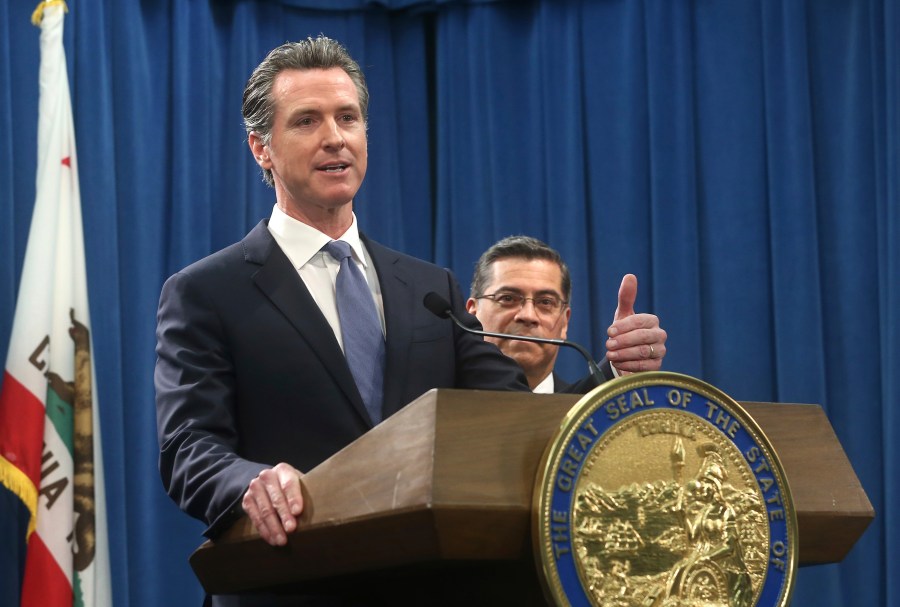 California Gov. Gavin Newsom, left, flanked by Attorney General Xavier Becerra, right, answers a question during a news conference in Sacramento on Feb. 15, 2019. (Rich Pedroncelli / Associated Press)