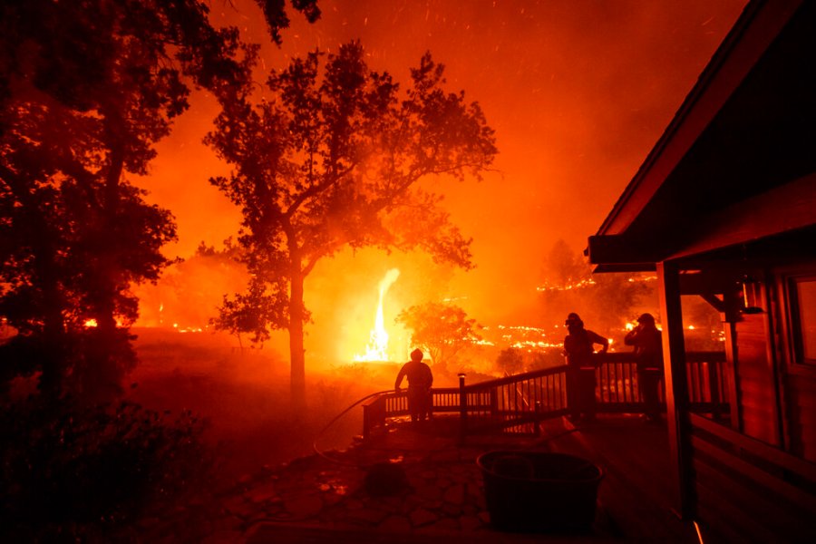 In this Aug. 21, 2020, file photo, firefighters watch flames from the LNU Lightning Complex fires approach a home in the Berryessa Estates neighborhood of unincorporated Napa County, Calif. (AP Photo/Noah Berger, File)