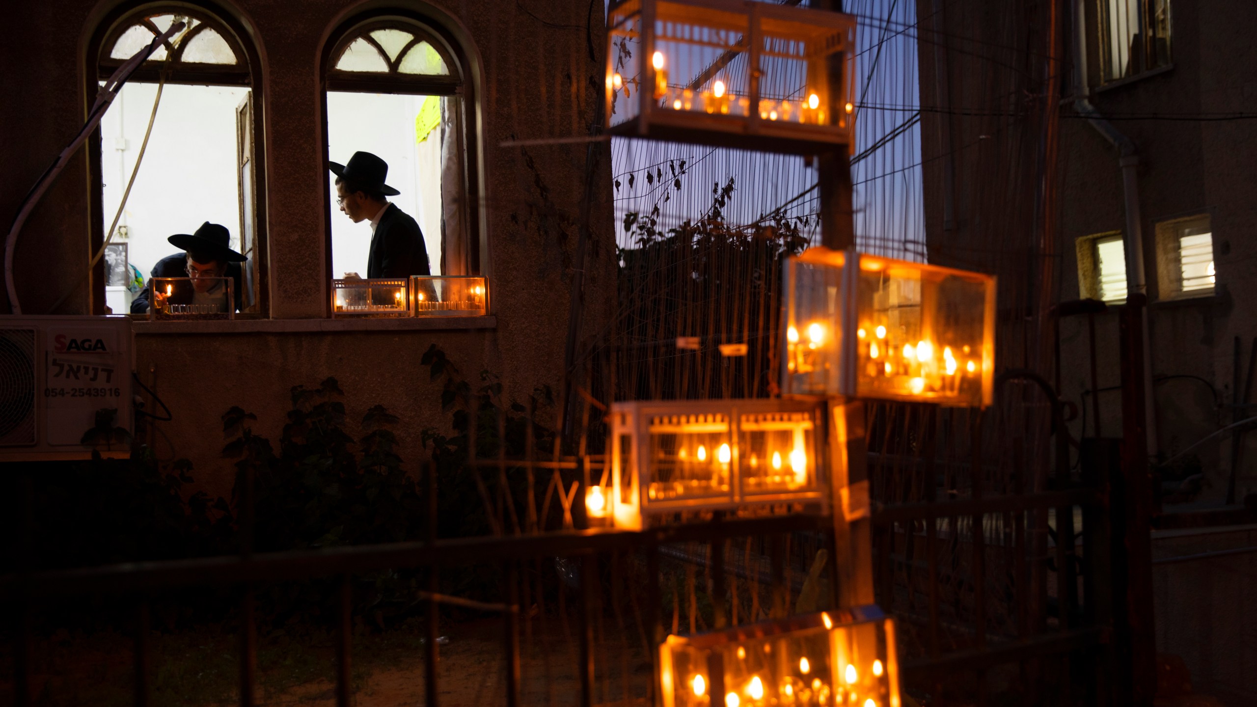 Ultra-Orthodox Jewish yeshiva students light candles on the first day of the Jewish holiday of Hanukkah in the ultra-Orthodox city of Bnei Brak near Tel Aviv, Israel, Thursday, Dec. 10, 2020. (Oded Balilty/AP Photo)