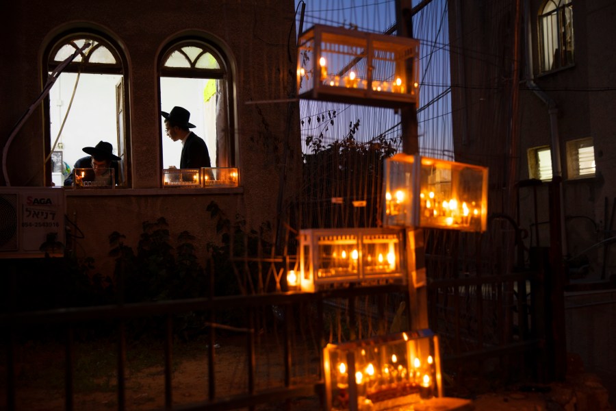 Ultra-Orthodox Jewish yeshiva students light candles on the first day of the Jewish holiday of Hanukkah in the ultra-Orthodox city of Bnei Brak near Tel Aviv, Israel, Thursday, Dec. 10, 2020. (Oded Balilty/AP Photo)