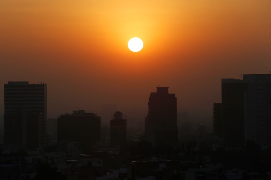 In this Thursday, Feb. 20, 2020 file photo, the sun rises amid smog during the dry season in Mexico City. Five years after a historic climate deal in Paris, world leaders are again meeting to increase their efforts to fight global warming. (AP Photo/Marco Ugarte)