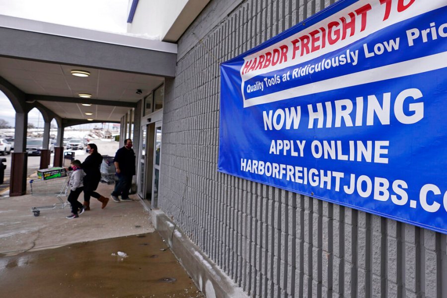 A "Now Hiring" sign hangs on the front wall of a Harbor Freight Tools store, Thursday, Dec. 10, 2020, in Manchester, N.H. (AP Photo/Charles Krupa)