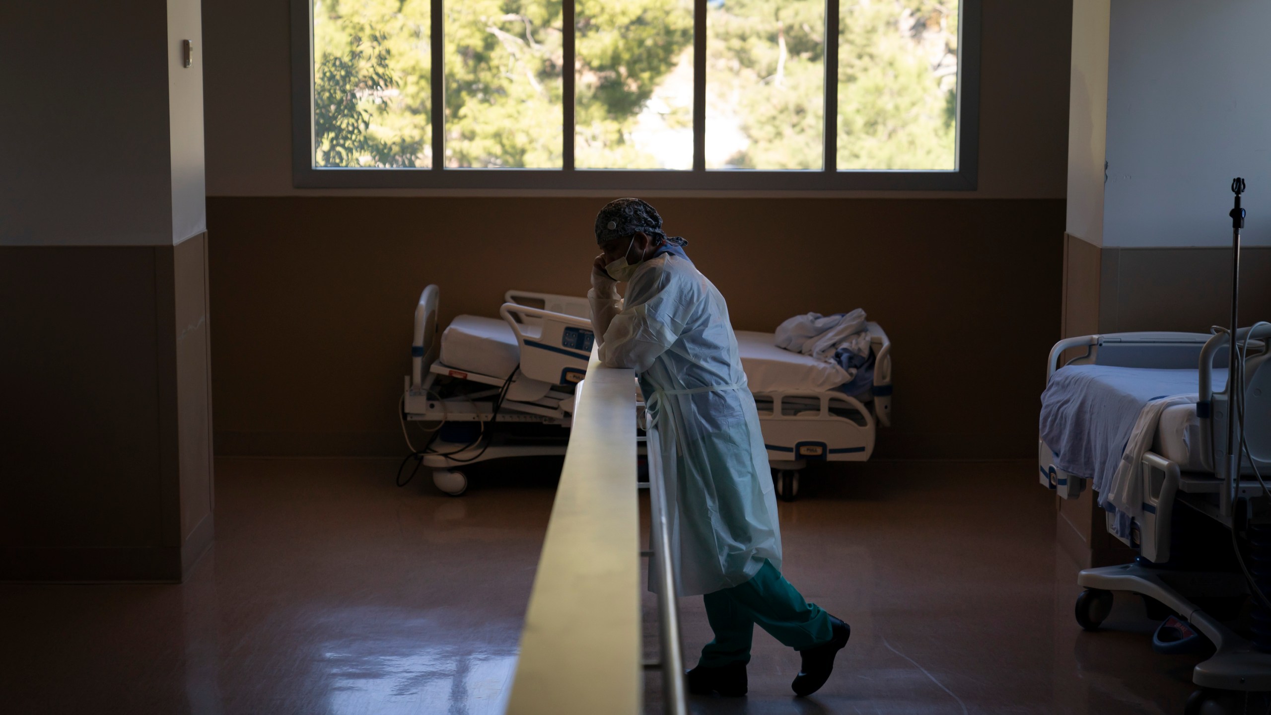 In this Nov. 19, 2020, file photo, respiratory therapist Babu Paramban talks on the phone next to hospital beds while taking a break in the COVID-19 unit at Providence Holy Cross Medical Center in the Mission Hills section of Los Angeles. (Jae C. Hong/AP Photo)