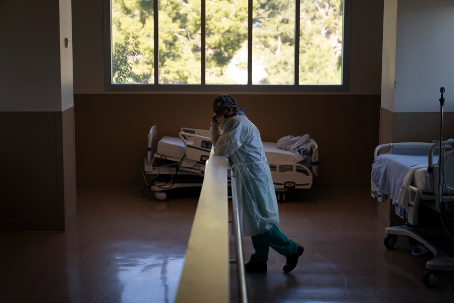 In this Nov. 19, 2020, file photo, respiratory therapist Babu Paramban talks on the phone next to hospital beds while taking a break in the COVID-19 unit at Providence Holy Cross Medical Center in the Mission Hills section of Los Angeles. (Jae C. Hong/AP Photo)