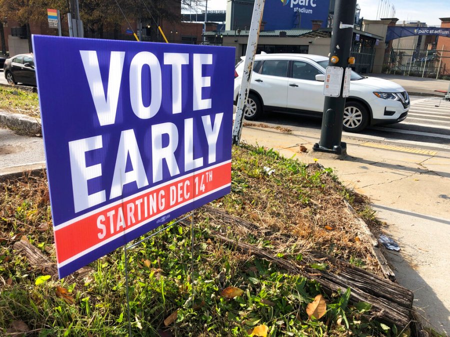 A sign in an Atlanta neighborhood on Friday, Dec. 11, 2020, urges people to vote early in Georgia's two U.S. Senate races. (AP Photo/Jeff Amy)