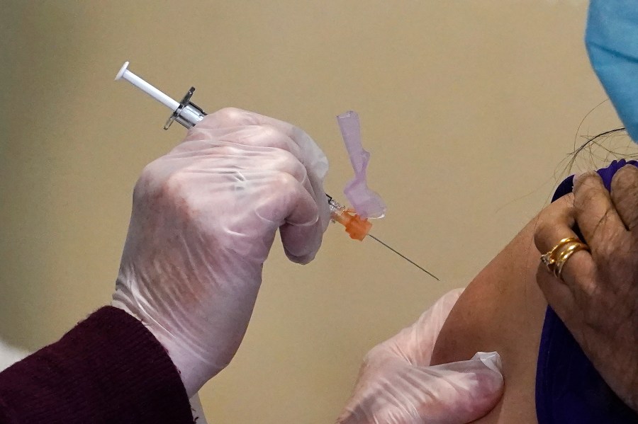 Registered nurse Allison Miller administers one of the first Pfizer-BioNTech COVID-19 vaccinations at UW Medicine in Seattle on Dec. 15, 2020. (Elaine Thompson / Associated Press)