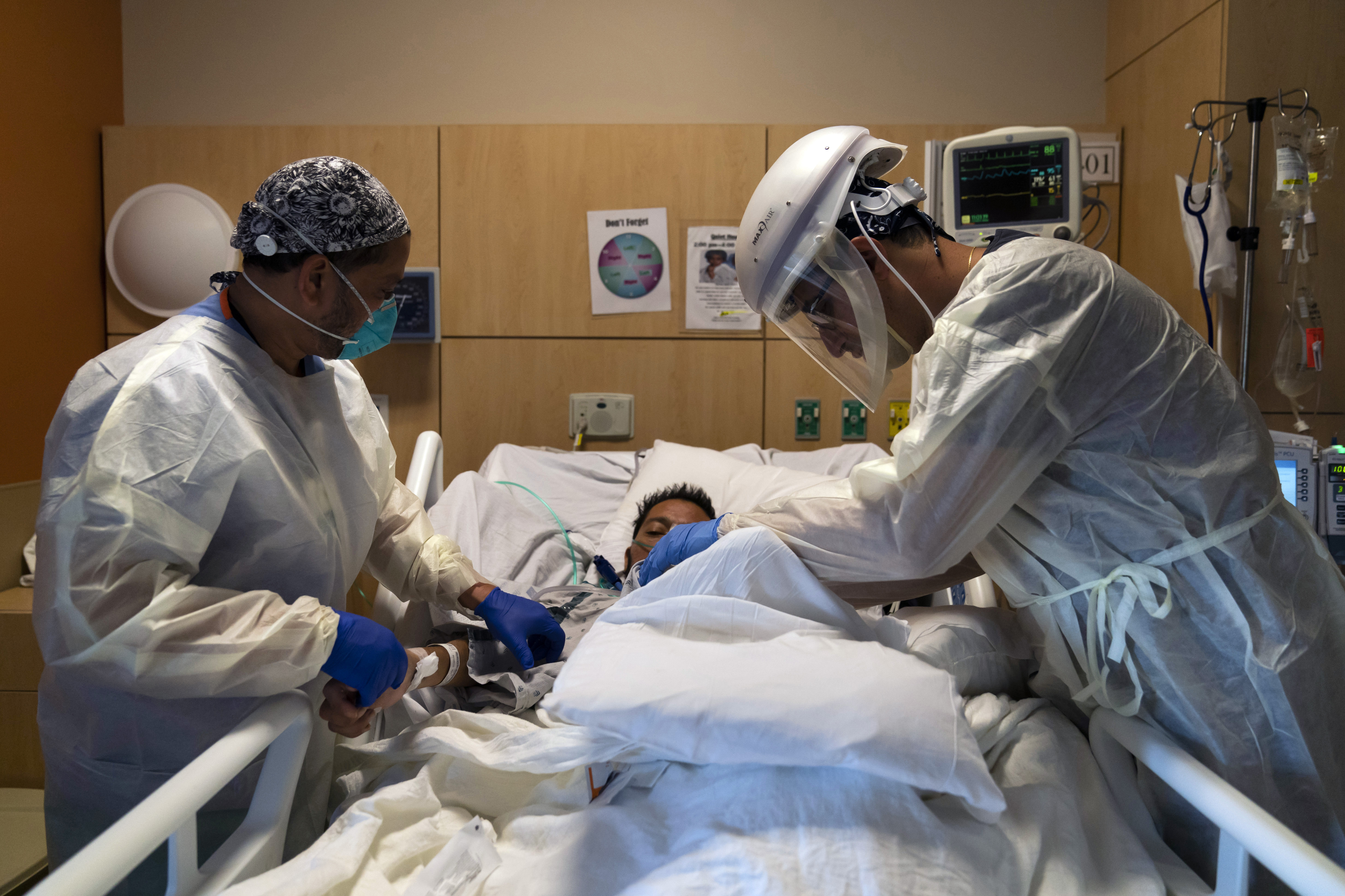 In this Nov. 19, 2020 file photo, Dr. Rafik Abdou, right, and respiratory therapist Babu Paramban check on a COVID-19 patient at Providence Holy Cross Medical Center in the Mission Hills section of Los Angeles. (Jae Hong/AP Photo)