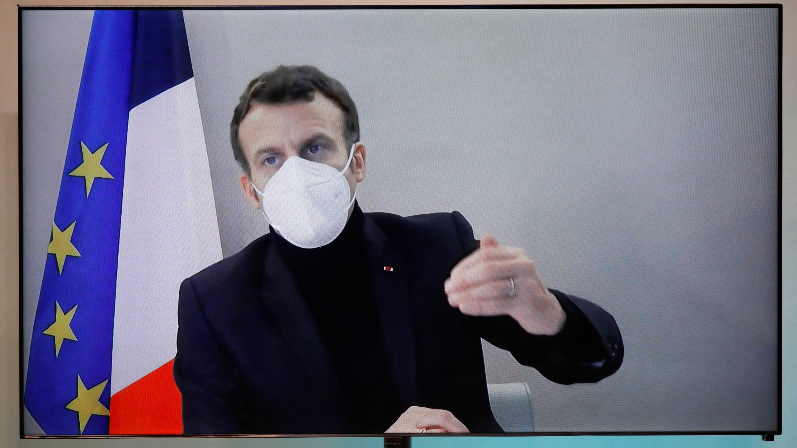 French President Emmanuel Macron is seen on a screen as he attends by video conference a round table for the National Humanitarian Conference (NHC), taken at the Foreign Ministry in Paris on Dec. 17, 2020. (Charles Platiau/Pool via Associated Press)