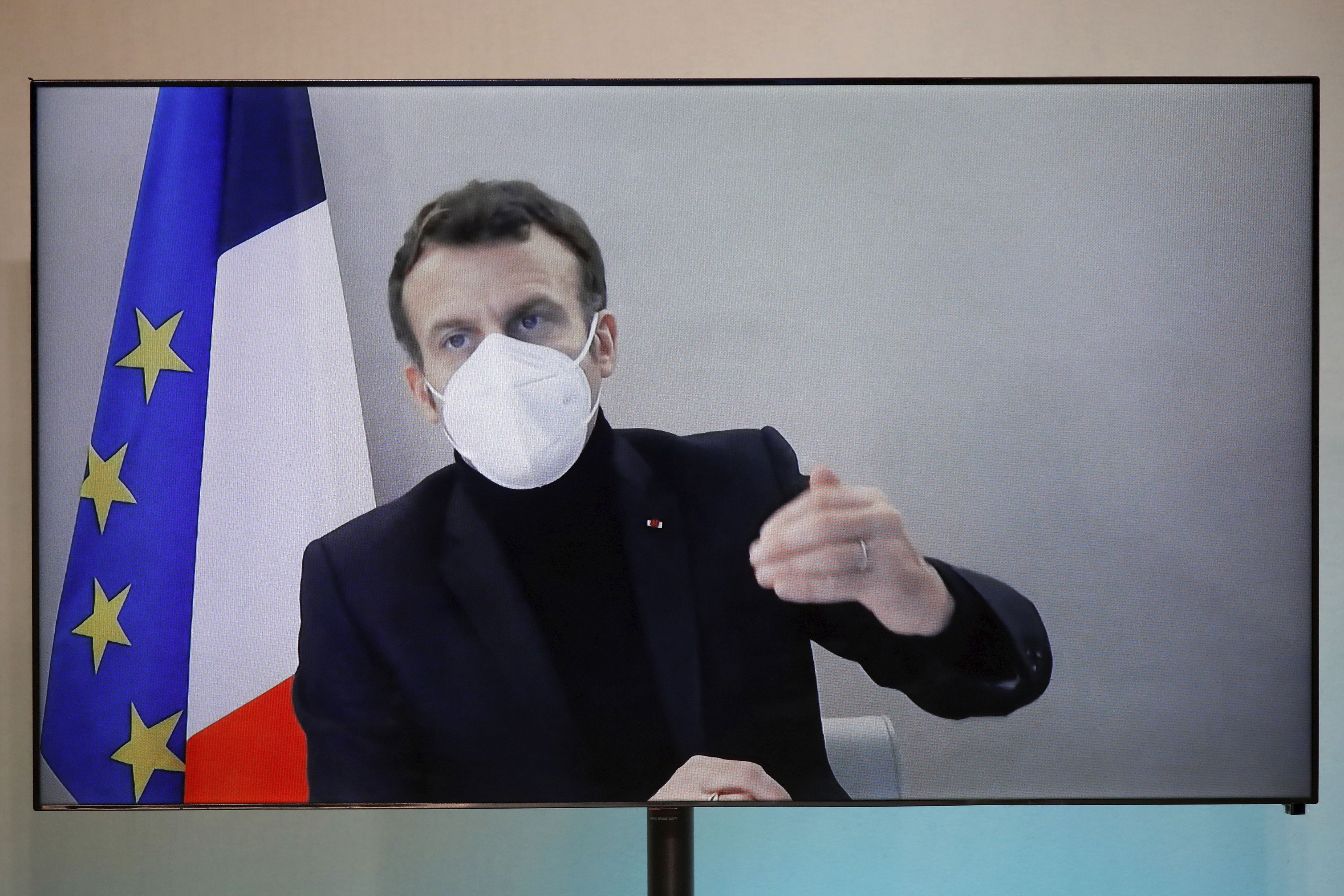 French President Emmanuel Macron is seen on a screen as he attends by video conference a round table for the National Humanitarian Conference (NHC), taken at the Foreign Ministry in Paris on Dec. 17, 2020. (Charles Platiau/Pool via Associated Press)