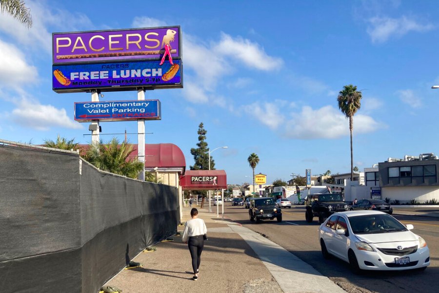 In this Dec. 10, 2020, file photo, a person walks past Pacers Showgirls International in San Diego. San Diego County has suspended enforcement of COVID-19 restrictions on restaurants and live entertainment establishments after a local judge found in favor of two strip clubs that defied a state shutdown order and indicated the ruling applied more broadly. (AP Photo/Elliot Spagat, File)