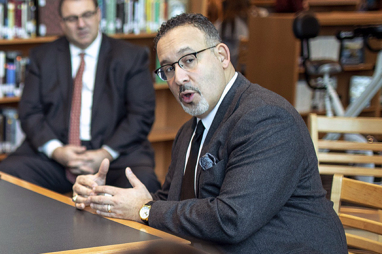 In this Jan. 28, 2020 file photo, Connecticut State Commissioner of Education Miguel Cardona speaks with Berlin High School students while on a tour of the school. (Devin Leith-Yessian/Berlin Citizen/Record-Journal via AP)