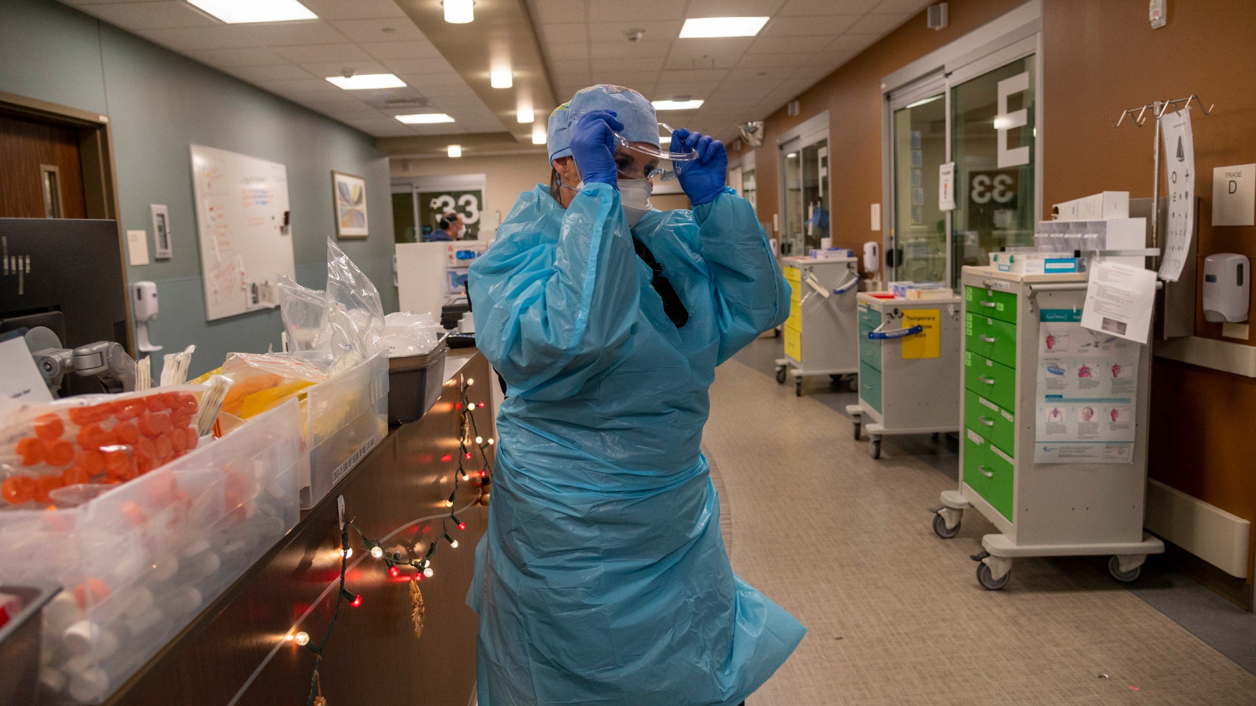 Registered Nurse Allison Shiftar puts on protective glasses as she gets ready to go into one of the triage rooms to care for a COVID-19 positive patient in the emergency department at Sutter Roseville Medical Center in Roseville, Calif. on Dec. 22, 2020. (Renee C. Byer/The Sacramento Bee via AP, Pool)