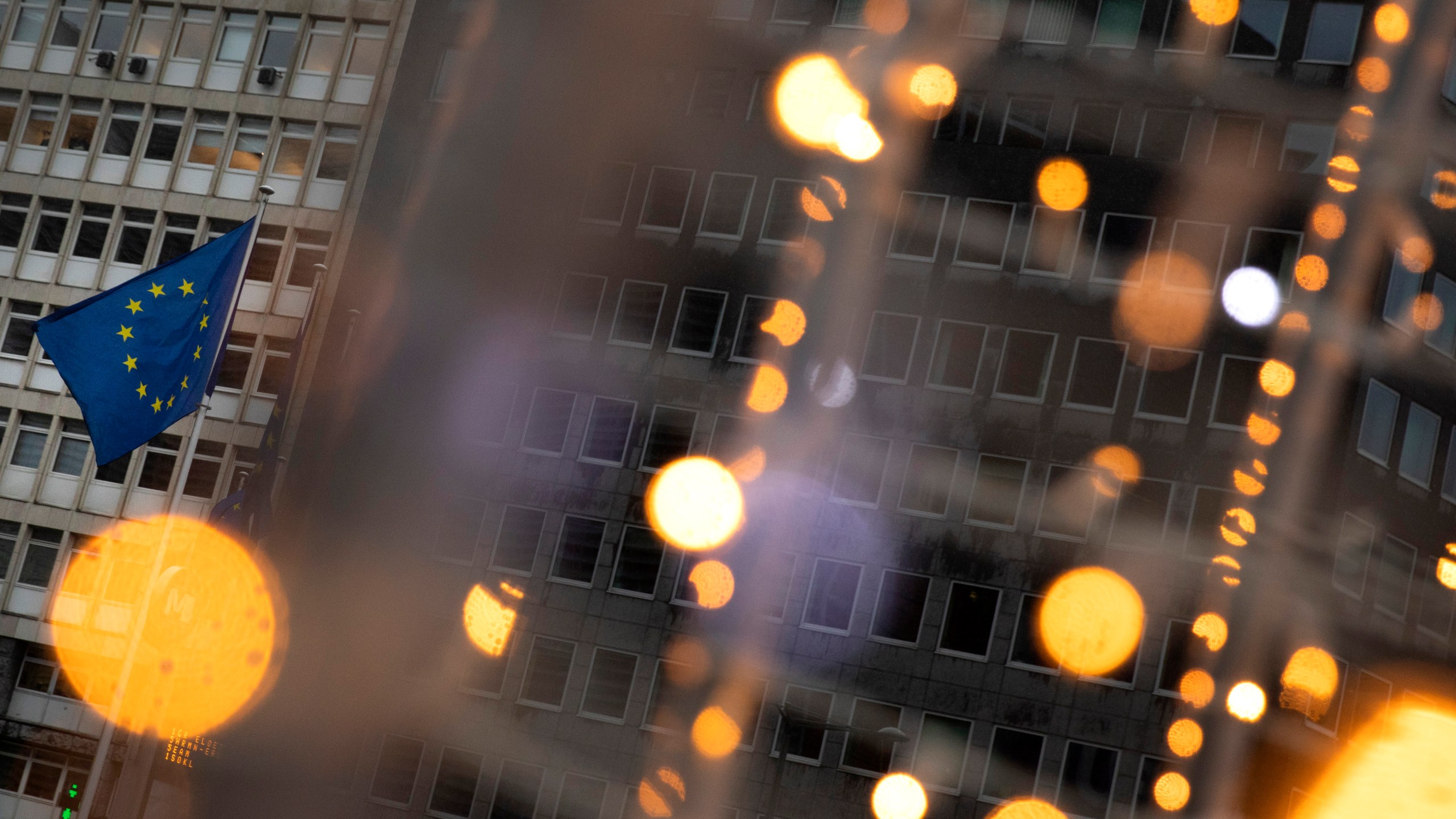 European Union flags flutter in the wind amongst Christmas decorations outside of EU headquarters in Brussels, on Dec. 23, 2020. (AP Photo/Virginia Mayo)