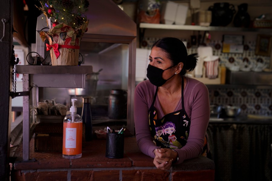 Debbie Briano, a fourth-generation owner of Mexican restaurant, El Rancho Grande, waits for customers in her restaurant on Olvera Street in downtown Los Angeles, Wednesday, Dec. 16, 2020. Even as the December light casts long shadows over the market, Briano is not giving up. She's serving takeout food and is paying five employees, including brothers who have worked there 55 years and 48 years each, but not herself. (Jae C. Hong / Associated Press)