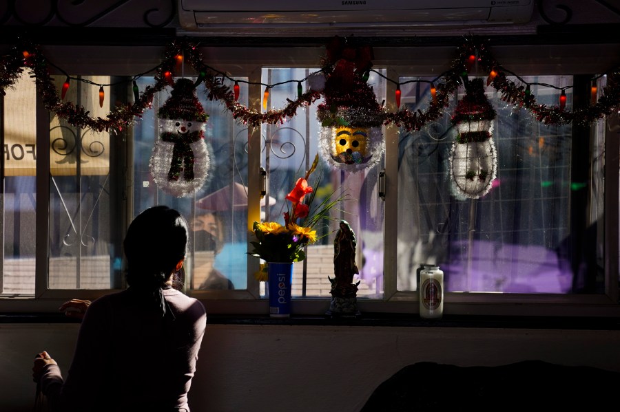 Debbie Briano, a fourth-generation owner of Mexican restaurant, El Rancho Grande, looks at her Christmas decorations in her restaurant on Olvera Street in downtown Los Angeles, Wednesday, Dec. 16, 2020. Briano still decorated her cafe like she normally would at Christmas. She bought poinsettias, put up a real tree, hung tinsel, lights, and strung little snowmen and Santa Claus above her window. "I had to do that to feel normal," she said. "I' m not going to let COVID take away our Christmas magic." (Jae C. Hong / Associated Press)