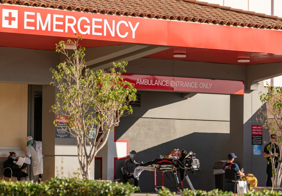 In this Dec. 18, 2020 file photo an unidentified patient receives oxygen on a stretcher, while Los Angeles Fire Department Paramedics monitor him outside the Emergency entrance, waiting for admission at the CHA Hollywood Presbyterian Medical Center in Los Angeles. (Damian Dovarganes/AP Photo)