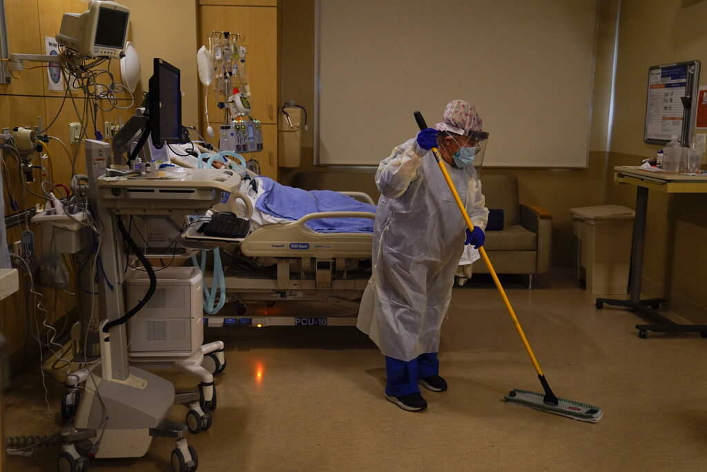 Hospital worker Alma Garibay mops the floor of a COVID-19 unit at Providence Holy Cross Medical Center in the Mission Hills area of Los Angeles on Dec. 22, 2020. (AP Photo/Jae C. Hong)