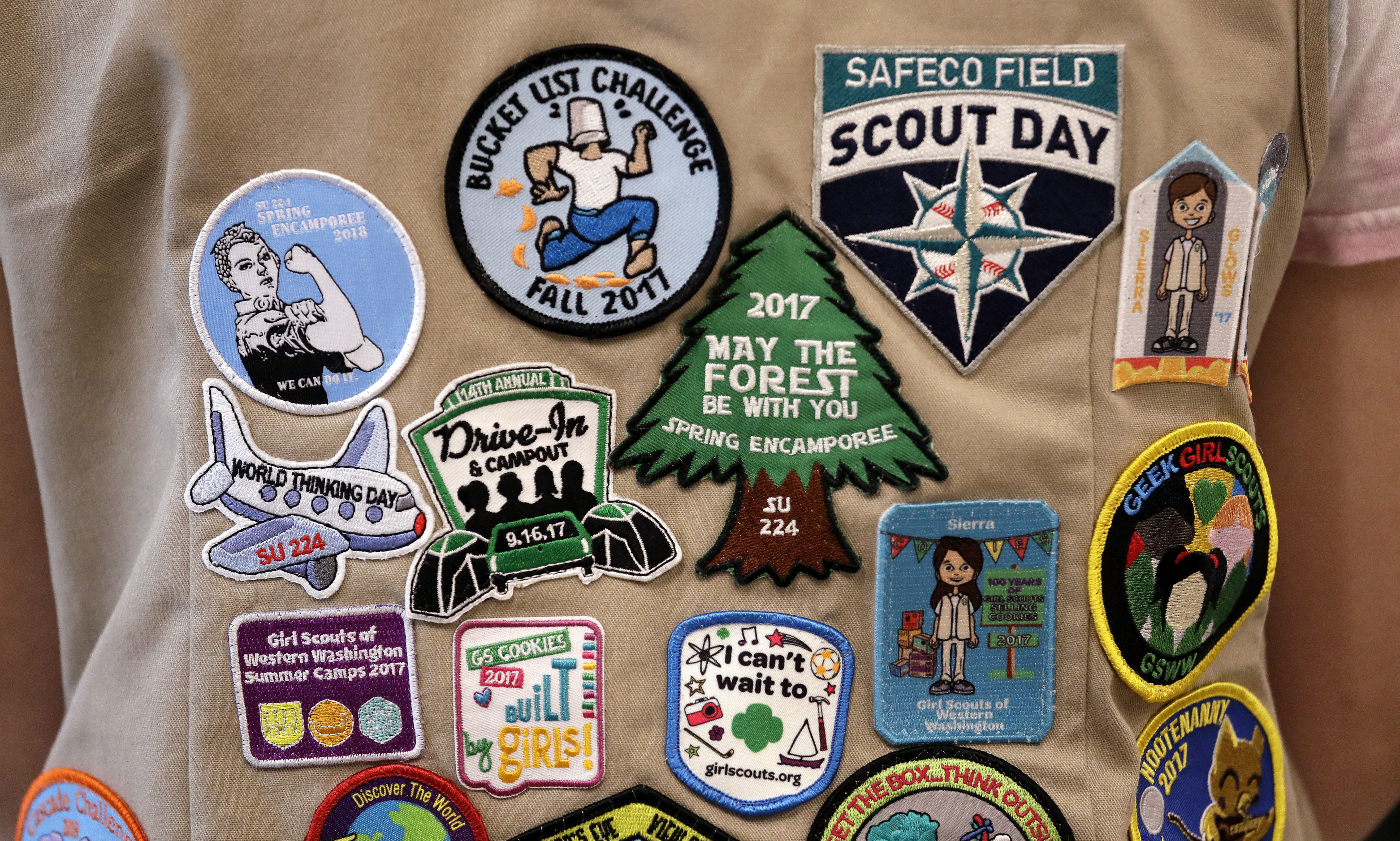 In this June 18, 2018, file photo, patches cover the back of a Girl Scout's vest at a demonstration of some of their activities in Seattle. (Elaine Thompson/AP Photo)