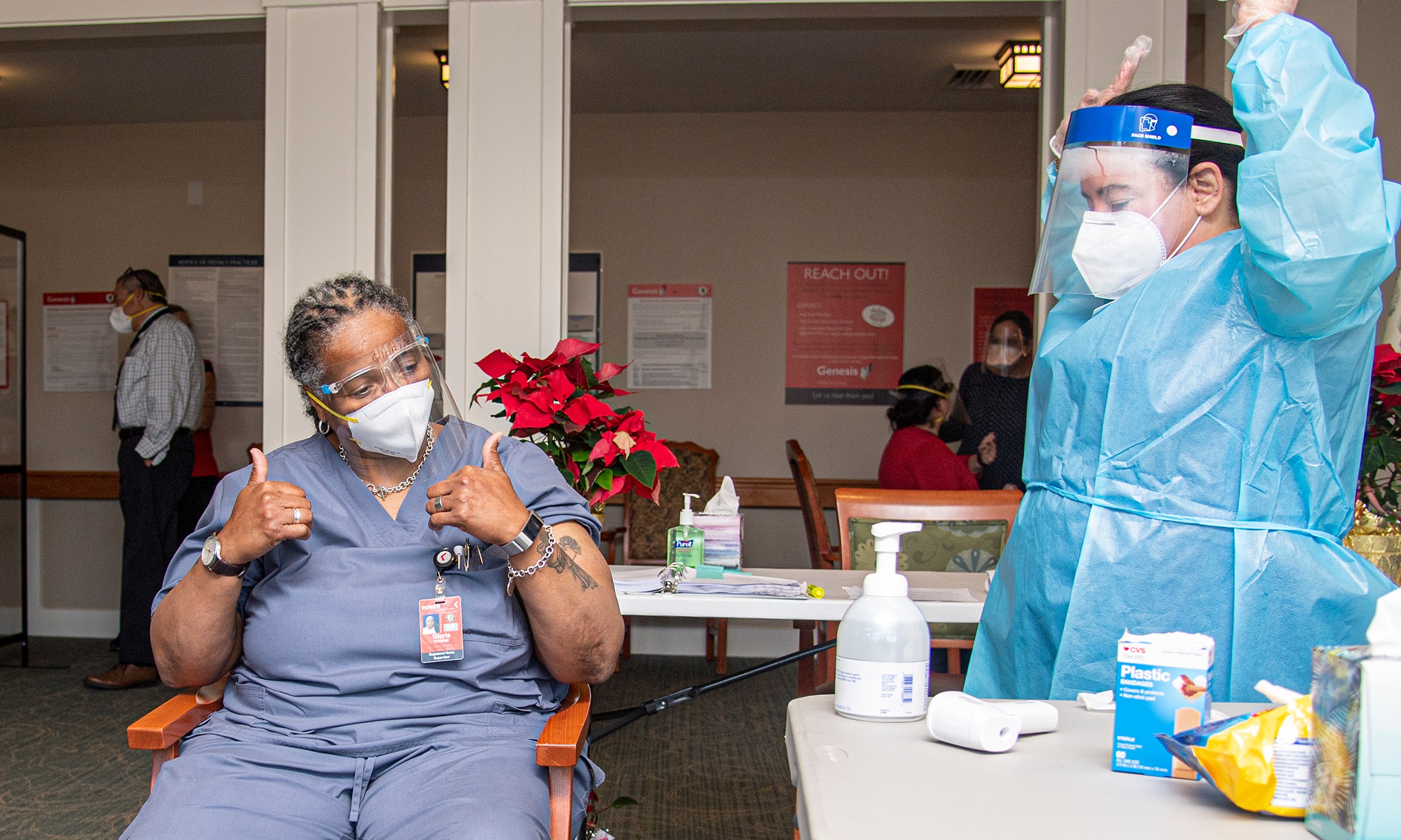 Pharmacist Nadine M. Mackey, right, and registered nurse Gloria Campbell, center, react after Campbell received a COVID-19 vaccination at PowerBack Rehabilitation, in Phoenixville, Pa., Monday, Dec. 28, 2020. (Jose F. Moreno/The Philadelphia Inquirer via AP)