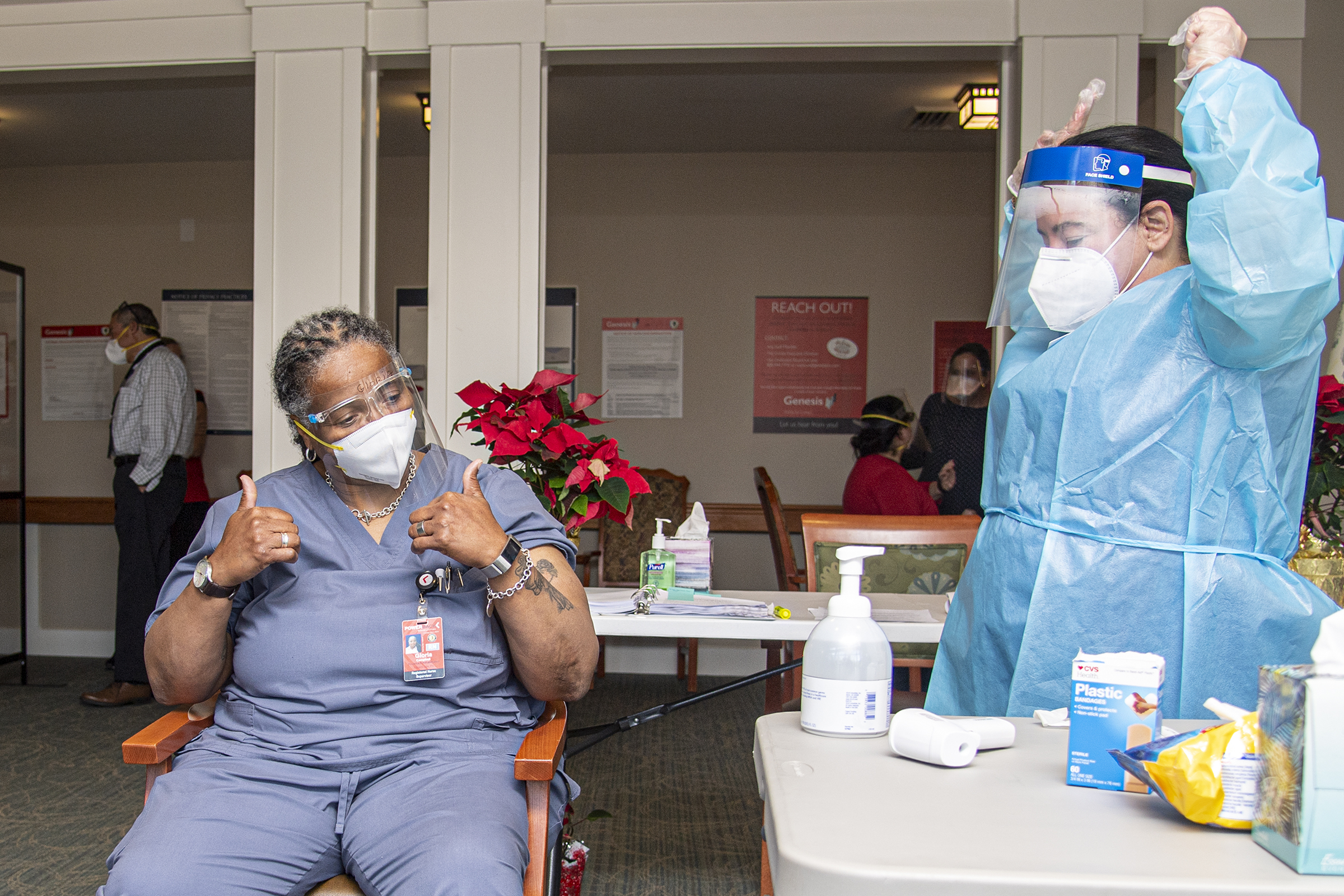 Pharmacist Nadine M. Mackey, right, and registered nurse Gloria Campbell, center, react after Campbell received a COVID-19 vaccination at PowerBack Rehabilitation, in Phoenixville, Pa., Monday, Dec. 28, 2020. (Jose F. Moreno/The Philadelphia Inquirer via AP)