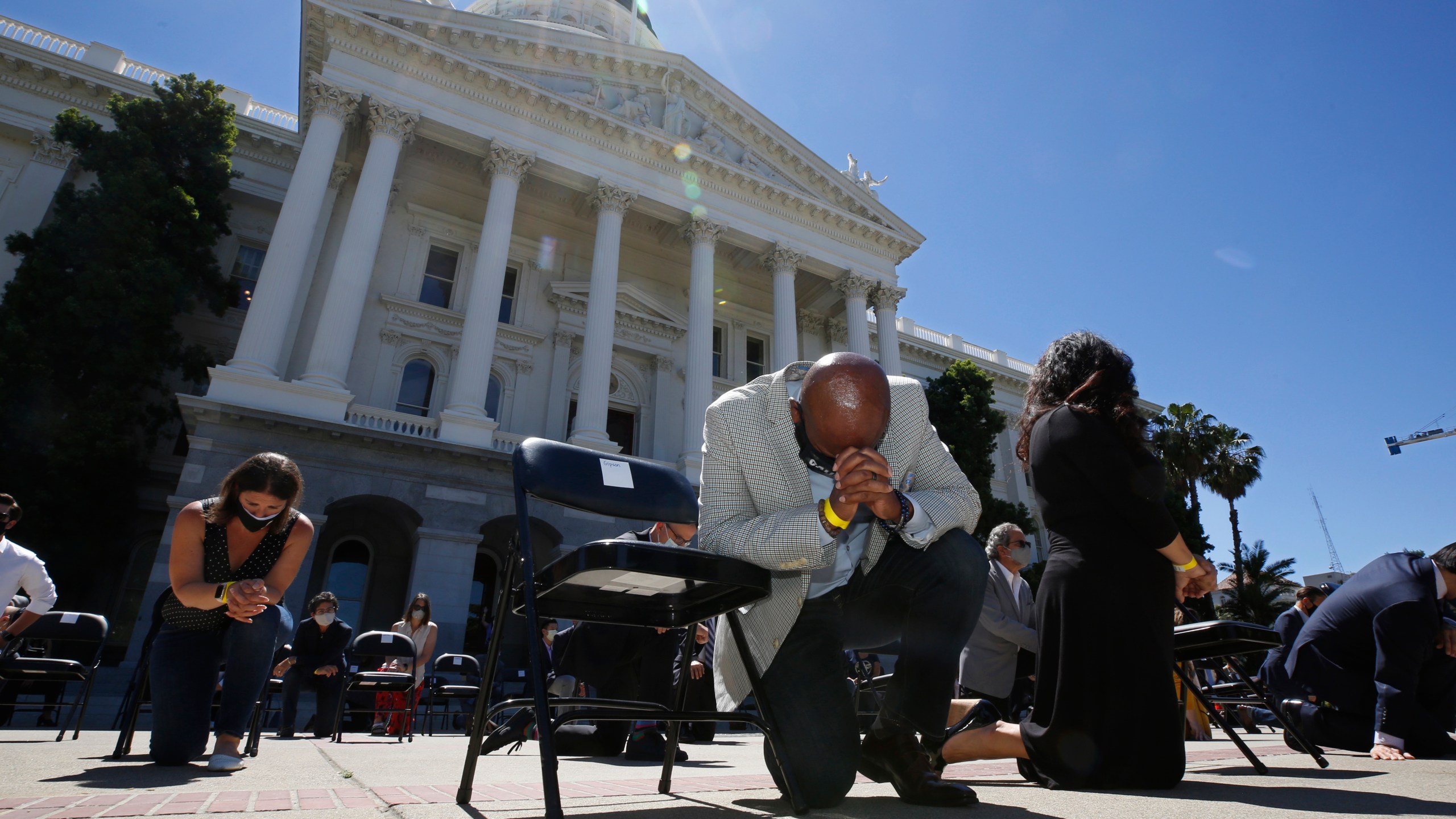 In this June 9, 2020, file photo, Assemblyman Mike Gipson, D-Carson, bows his head as he and other members of the California Legislature kneel to honor George Floyd at the Capitol in Sacramento. (AP Photo/Rich Pedroncelli, File)