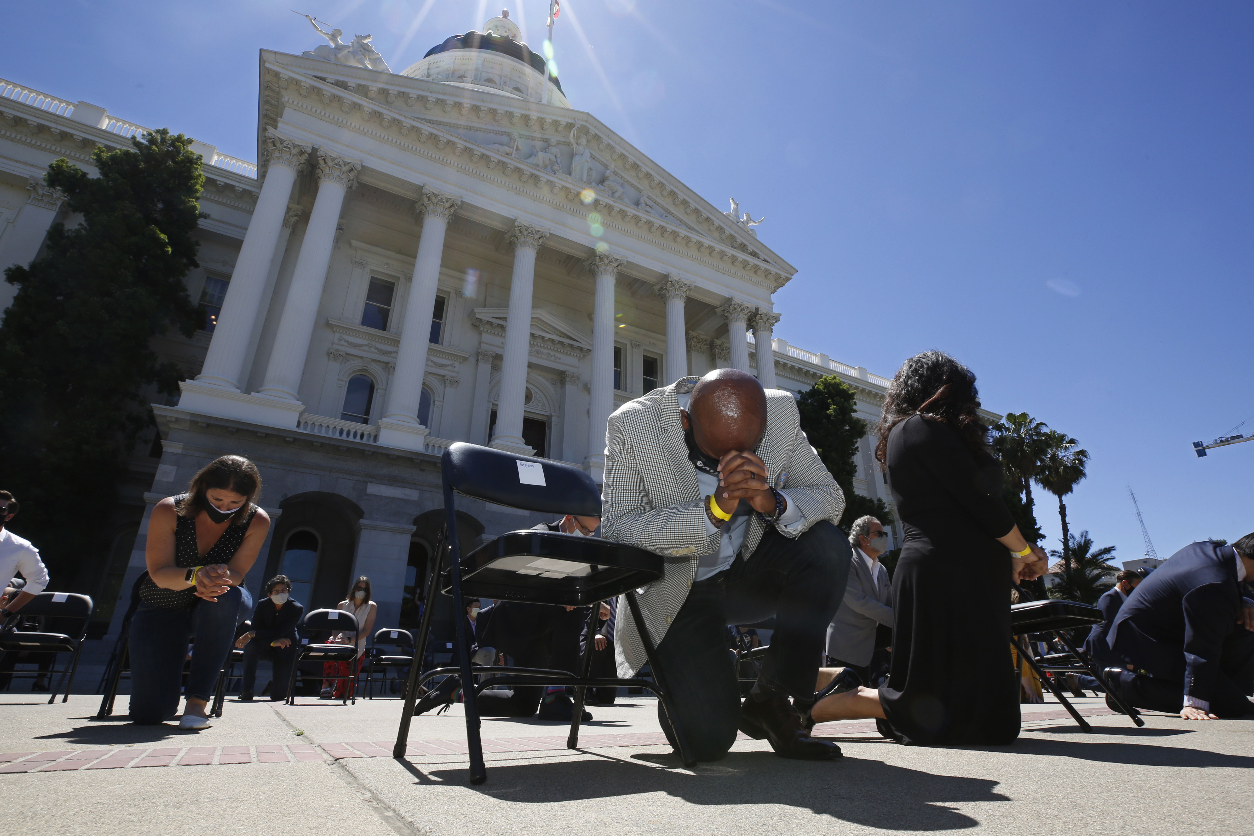 In this June 9, 2020, file photo, Assemblyman Mike Gipson, D-Carson, bows his head as he and other members of the California Legislature kneel to honor George Floyd at the Capitol in Sacramento. (AP Photo/Rich Pedroncelli, File)