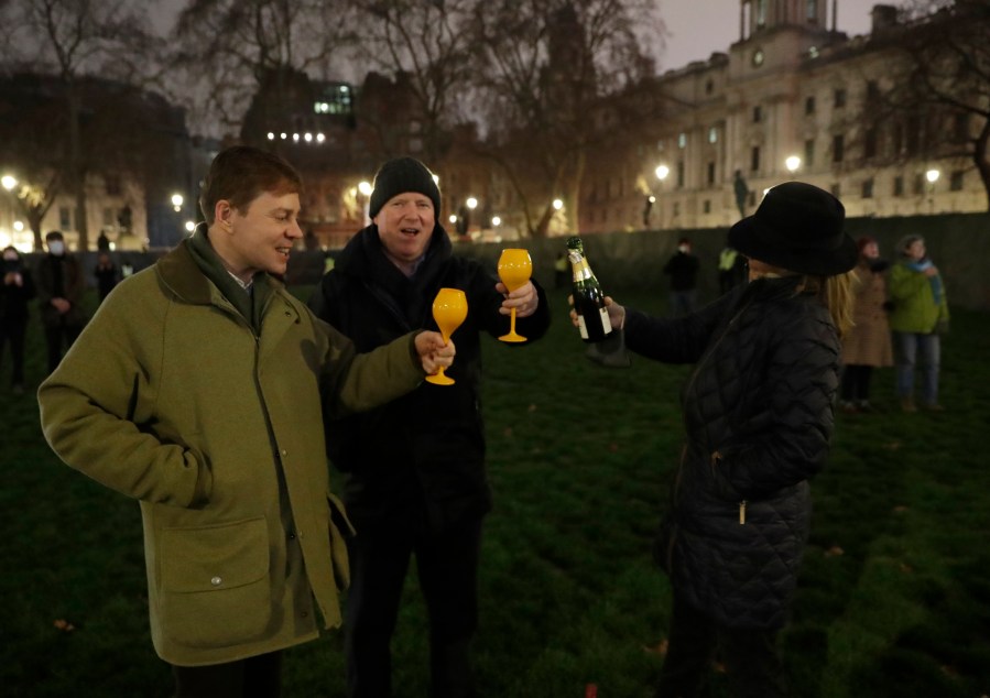 People raise a glass and celebrate in Parliament Square as the bell known as Big Ben strikes 2300, and Britain ends its transition period and formally leaves the European Union on Dec. 31, 2020. (Matt Dunham/Associated Press)