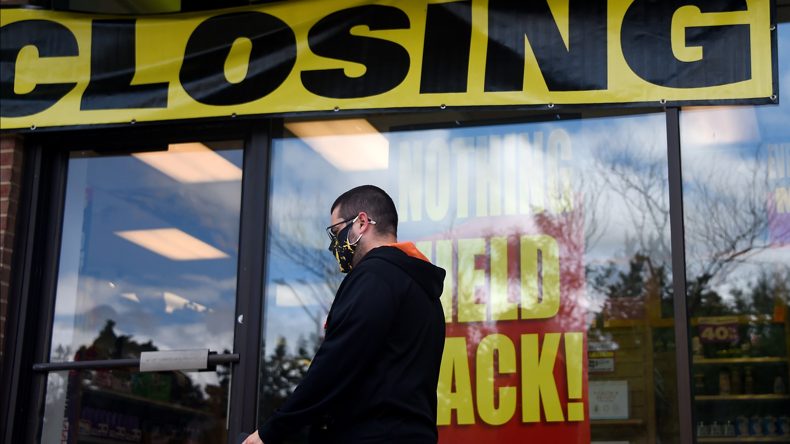 A man walks past a store before it closed down permanently on Aug.4, 2020 in Arlington, Virginia. (OLIVIER DOULIERY/AFP via Getty Images)