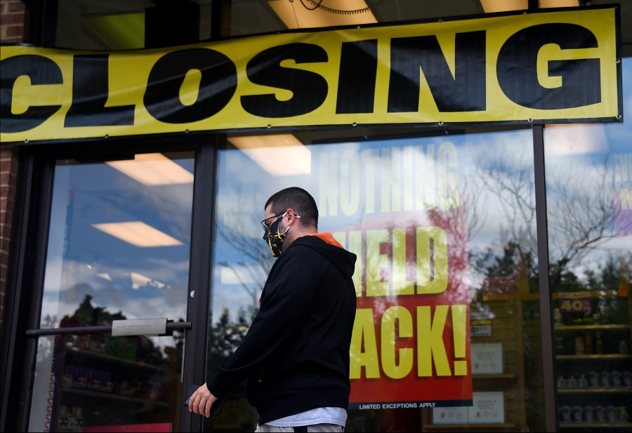 A man walks past a store before it closed down permanently on Aug.4, 2020 in Arlington, Virginia. (OLIVIER DOULIERY/AFP via Getty Images)