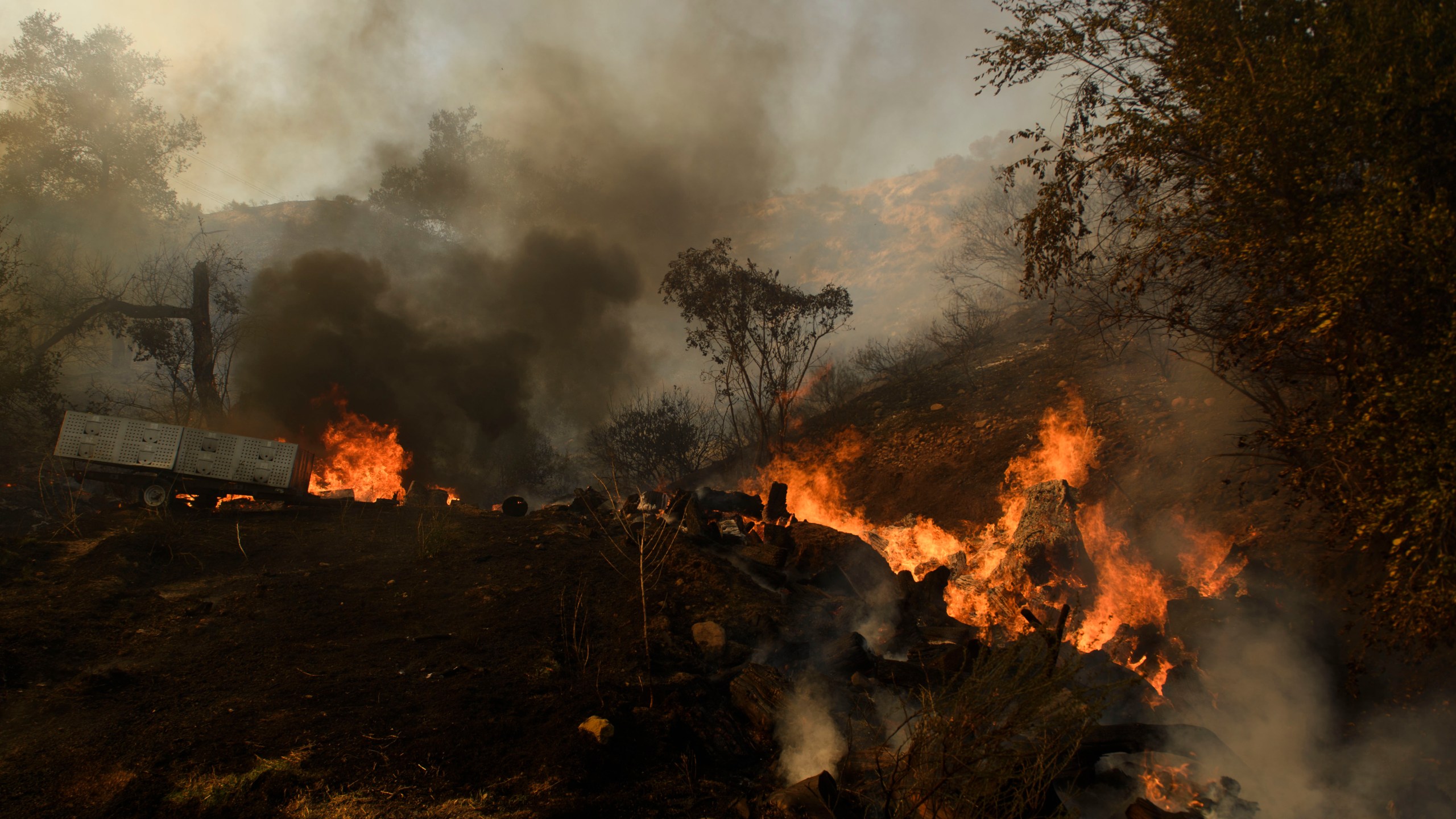 Debris burns behind a structure during the Bond Fire near Lake Forest, California on Dec. 3, 2020. (PATRICK T. FALLON/AFP via Getty Images)