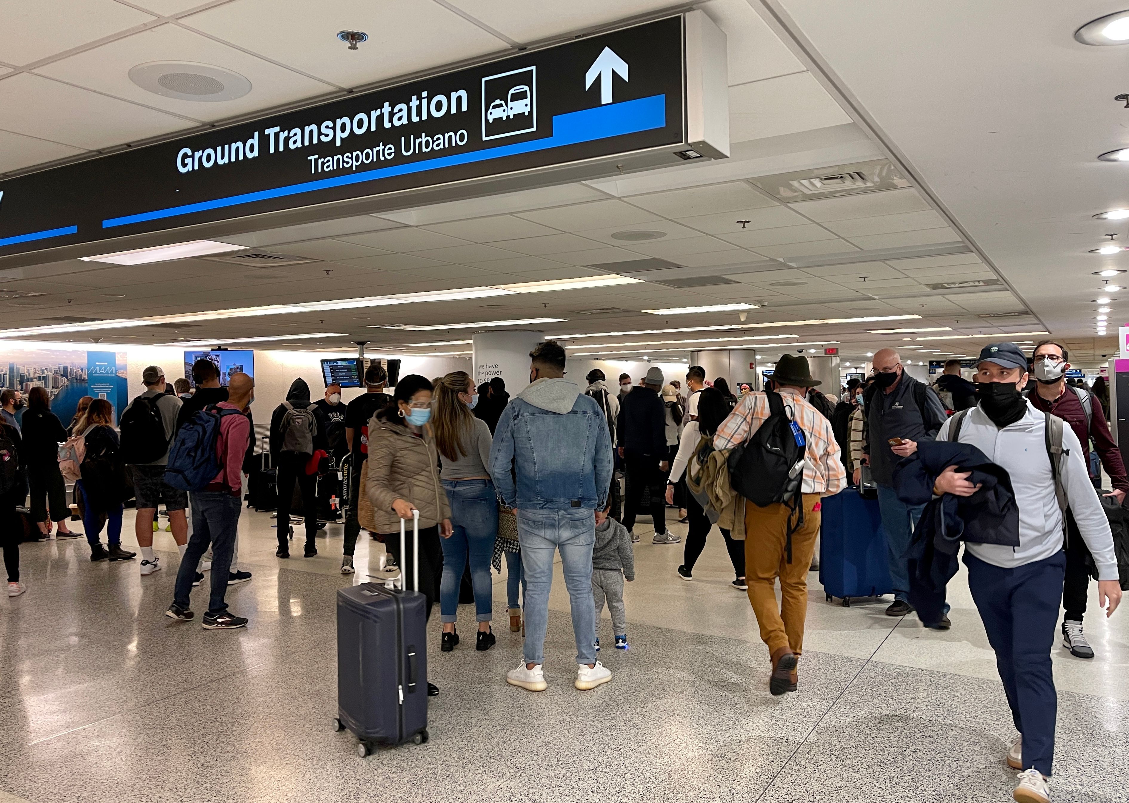 A crowd is seen, on Dec. 18, 2020 waiting by the baggage carousel at the Miami International Airport in Miami, Florida, as the Christmas holiday travel starts despite the coronavirus pandemic. (DANIEL SLIM/AFP via Getty Images)