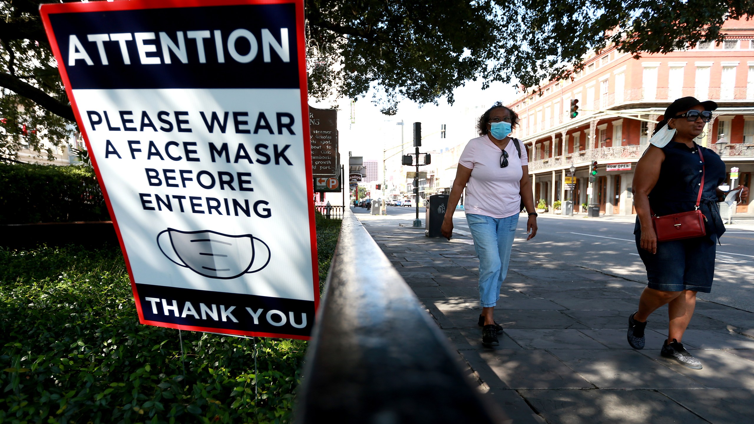 Visitors walk past face mask signs along Decatur Street in the French Quarter on July 14, 2020, in New Orleans, Louisiana. (Sean Gardner/Getty Images)