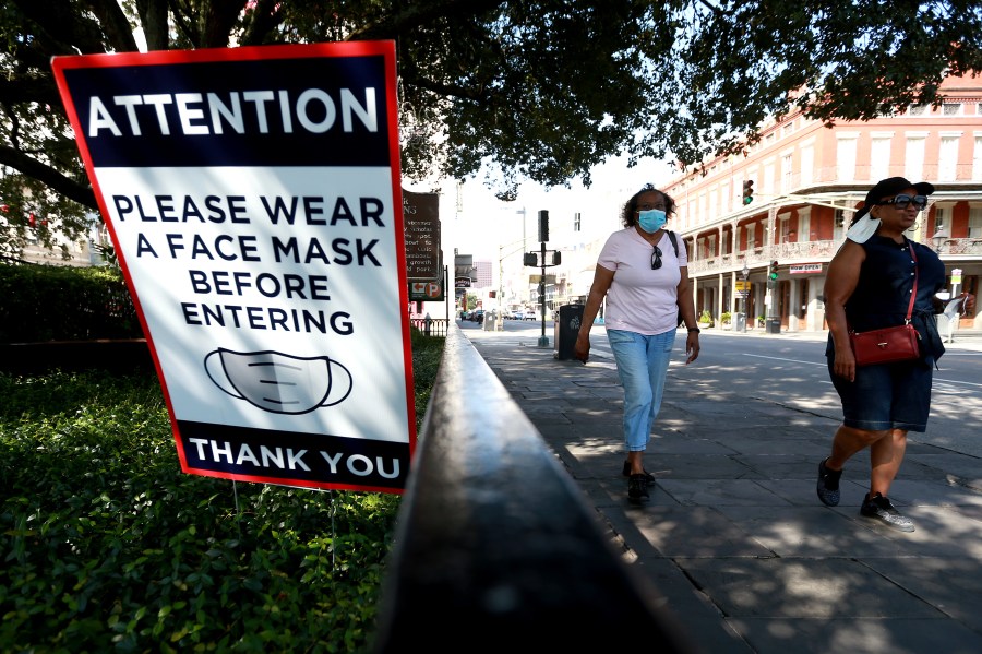 Visitors walk past face mask signs along Decatur Street in the French Quarter on July 14, 2020, in New Orleans, Louisiana. (Sean Gardner/Getty Images)