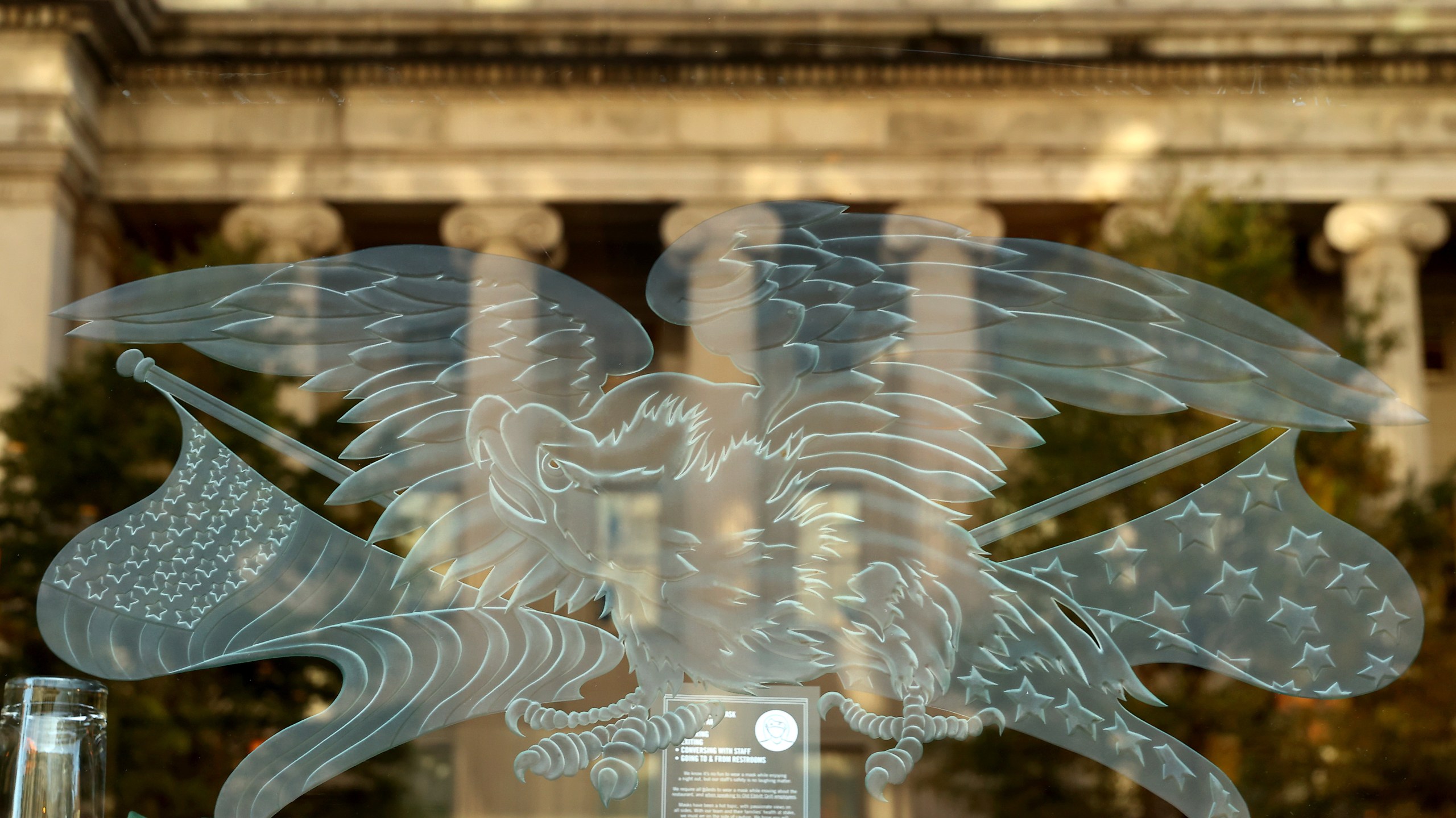 The U.S. Treasury Department is reflected in a restaurant window less than 24 hours before Election Day, on Nov. 2, 2020, in Washington, DC. (Chip Somodevilla/Getty Images)