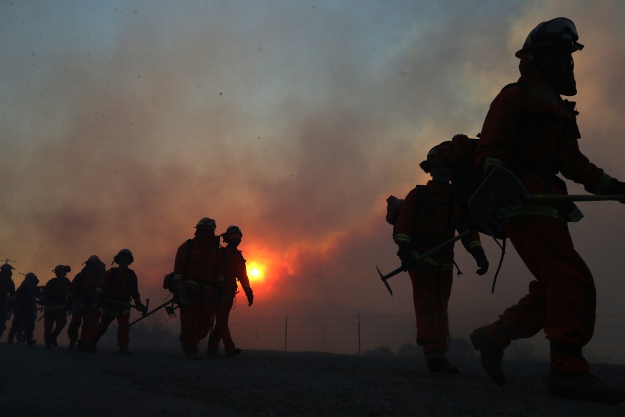 Inmate firefighters work as the Bond Fire burns shortly after sunrise in the Silverado Canyon area of Orange County on Dec. 3, 2020 near Irvine, California. (Mario Tama/Getty Images)