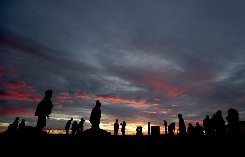 A small crowd takes in the sunset from the top of Signal Hill. Los Angeles County officials are bracing for another COVID-19 surge in early January.(Luis Sinco / Los Angeles Times)