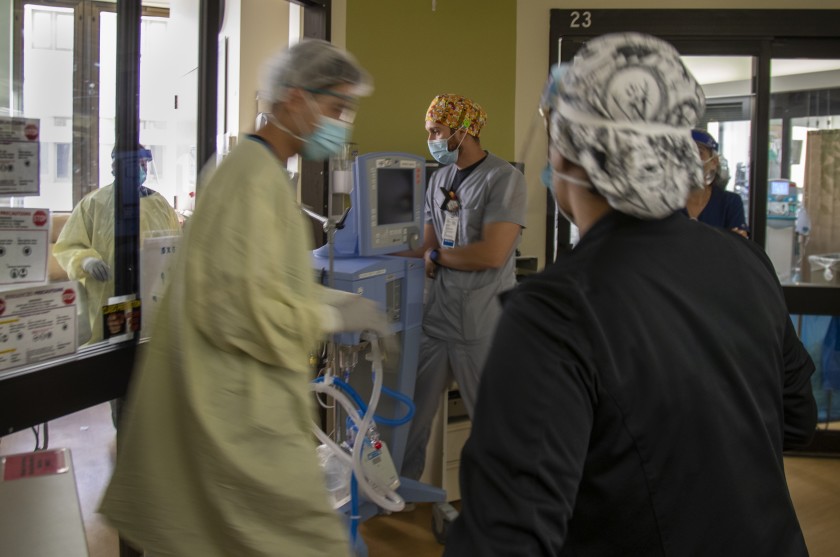 Pulmonologist Dr. Laren Tan, left, gathers his team of nurses and respiratory therapists to intubate a COVID-19 patient in the intensive care unit at Loma Linda University Medical Center in San Bernardino County on Tuesday.(Gina Ferazzi / Los Angeles Times)