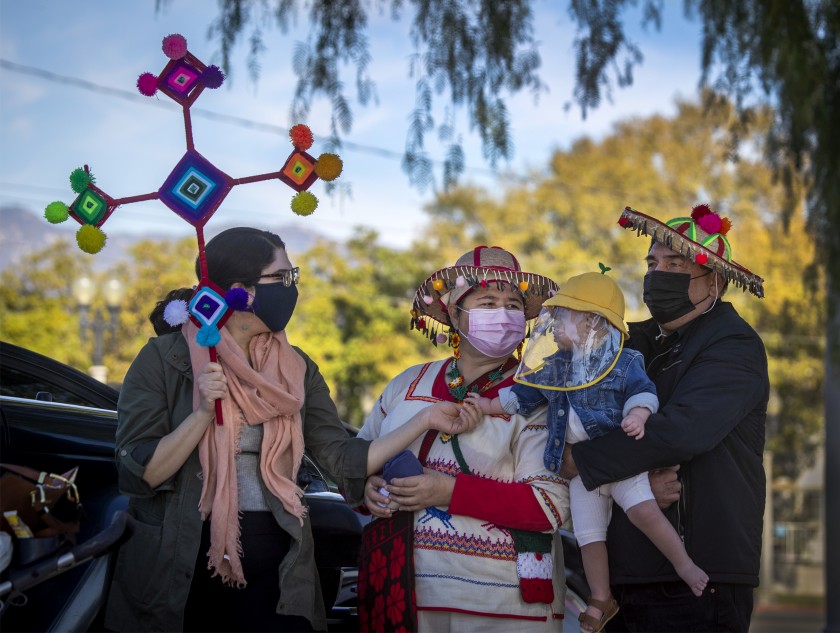 Lia Cervantes, left, and her parents, Francisca Lerma and Nahut Cervantes, share a moment with Lia Cervantes’ son Oliver Renteria during the annual procession in honor of Our Lady of Guadalupe. The family paid tribute to the Virgen de Guadalupe for helping Oliver get through a surgery for a congenital heart defect this year. (Allen J. Schaben/Los Angeles Times)