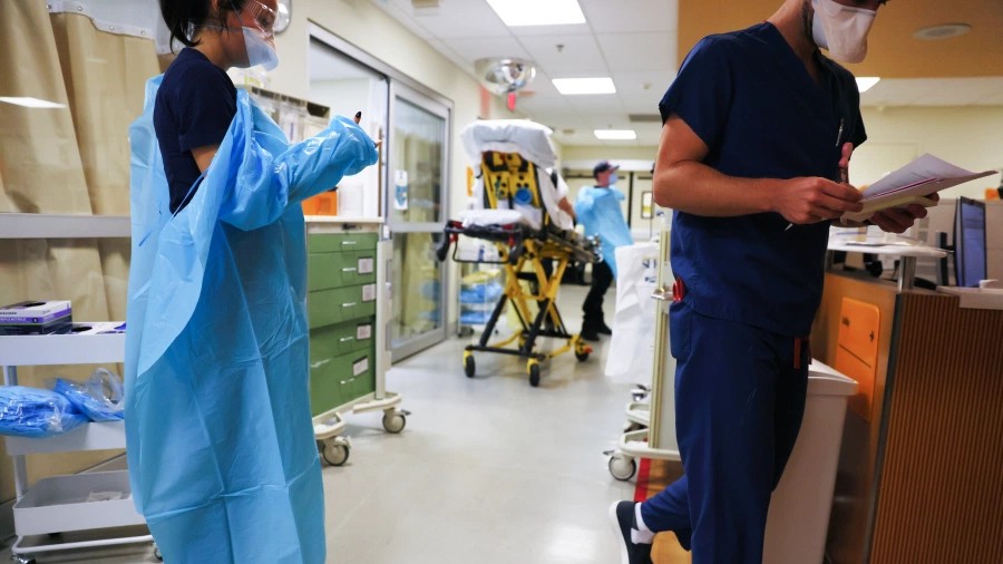 A clinician dons PPE (personal protective equipment) as she prepares to enter a patient's room in the emergency room at Sharp Memorial Hospital on December 15, 2020 in San Diego, California. (Mario Tama/Getty Images)