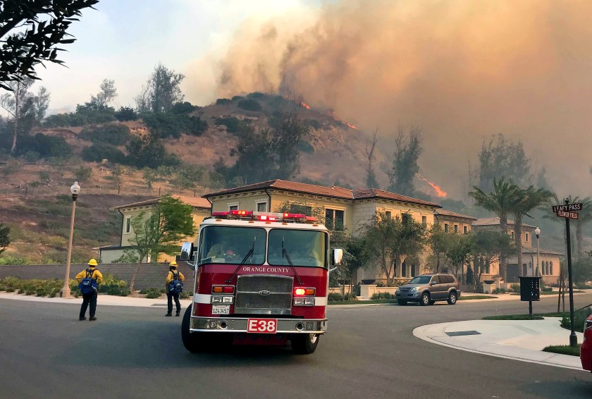 Firefighters stand ready to protect structures in Irvine’s Orchard Hills neighborhood from the Silverado fire.(Allen J. Schaben / Los Angeles Times)