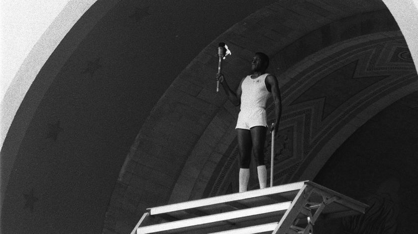 Rafer Johnson prepares to light the Olympic flame at the Los Angeles Coliseum to open the 1984 Summer Games.(Jayne Oncea / Los Angeles Times)