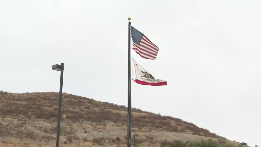 A U.S. and California flag fly in the air as wind blows through Santa Clarita on Dec. 7, 2020. (KTLA)