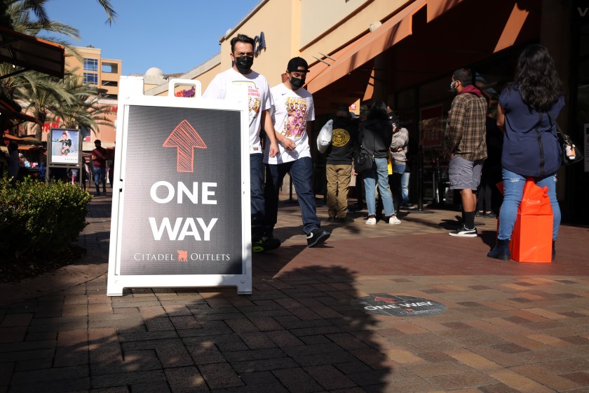 People walk against the suggested flow of foot traffic for coronavirus precautions at the Citadel Outlets in Commerce on Tuesday.(Dania Maxwell / Los Angeles Times)