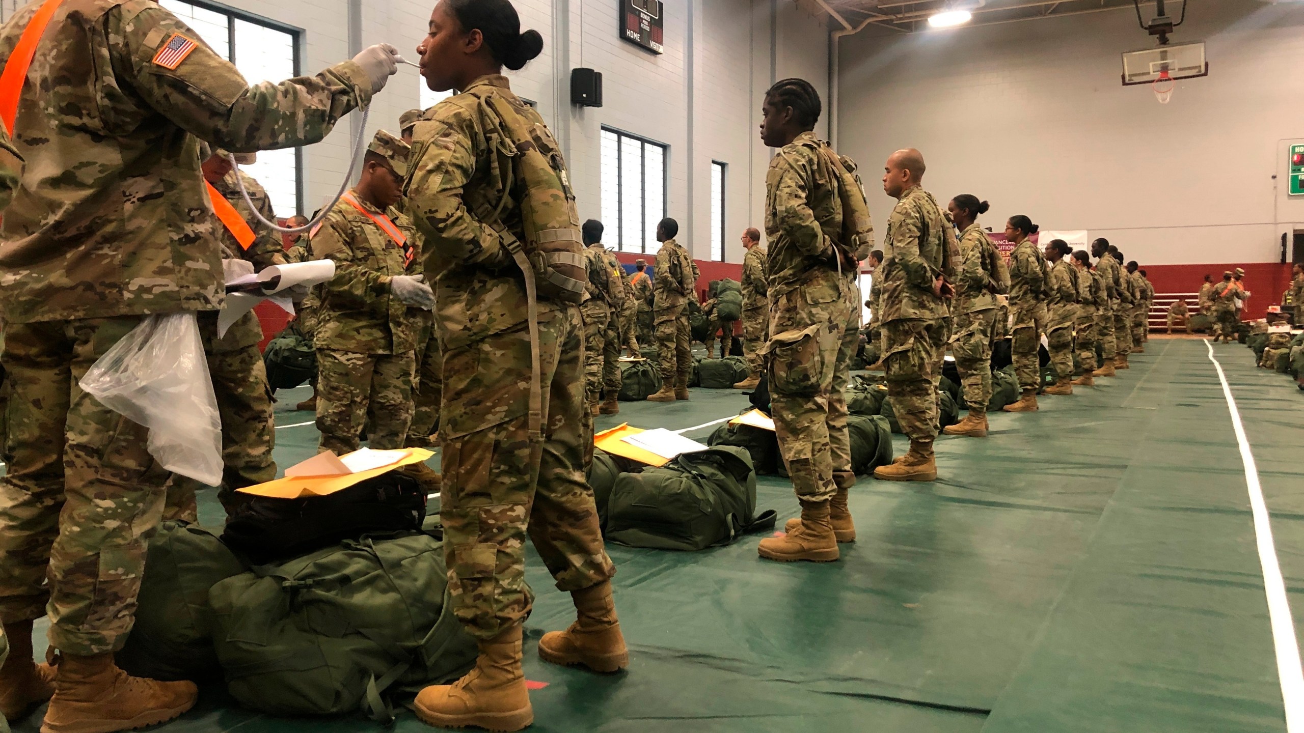 In this image provided by the U.S. Army, recent Army basic combat training graduates have their temperatures taken as they arrive at Fort Lee, Va, on March 31, 2020. (U.S. Army via AP)